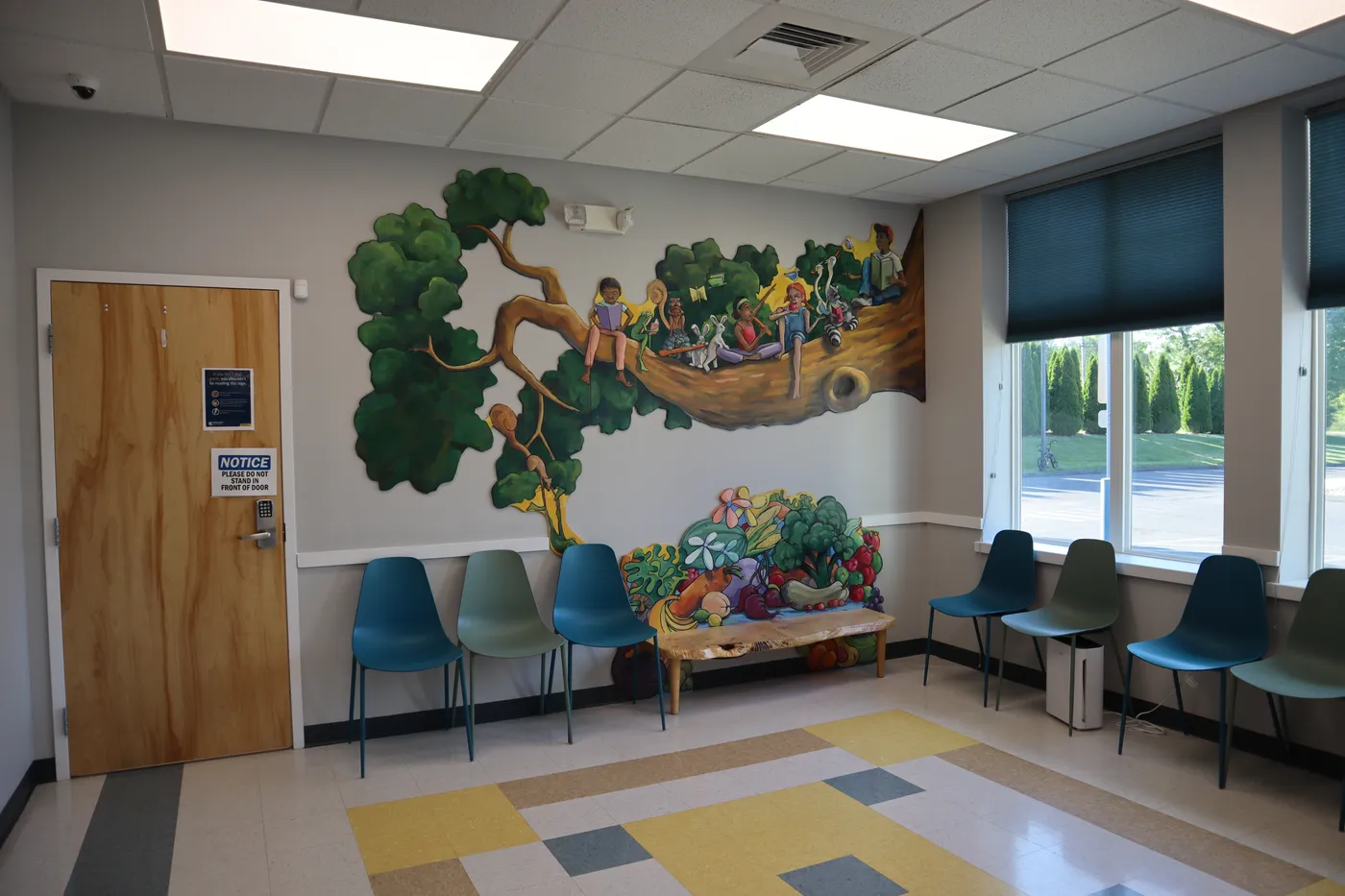 The kid-friendly waiting room at The Pediatric Care Center, with a painted tree mural